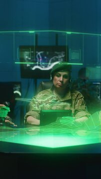 Medium shot of soldiers remote controlling a combat drone in a military base using futuristic holographic table technology. Vertical shot