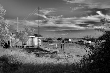Tranquil waters embrace a picturesque scene of fishing boats and rustic huts along the shores of...
