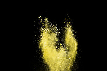 abstract powder splatted background. Freeze motion yellow powder explosion on black background