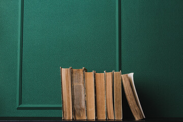Old books on a green background. Education and knowledge concept. There is space for copy space