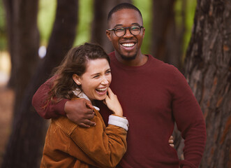 Fototapeta premium Love, happiness and portrait of couple in outdoor for camping in wilderness on anniversary date in Norway, countryside. Interracial people, travel and hug on holiday in forest for peace and adventure
