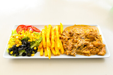 Turkish and Arabic Traditional Ramadan doner kebab with tasty tomato sauce and rice or turkish pilav in white plate on wood table background. ( Pilav ustu doner). Ekmek arasi doner, doner durum. 