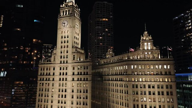 Drone footage of The Wrigley Building in Michigan Avenue at night with the city lights in Chicago