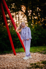 In the warm glow of sunset, a child beams with happiness at the playground, encapsulating the carefree joy of childhood