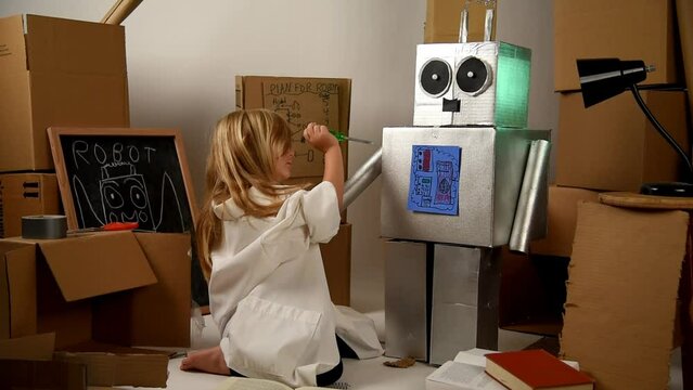 A child science student is inventing a metal robot out of cardboard boxes with tools. The girl is wearing a lab coat. Use it for an education or imagination concept.