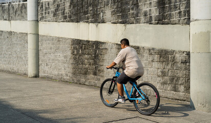 hombre latino de mediana edad paseando en su bicicleta al aire libre 
