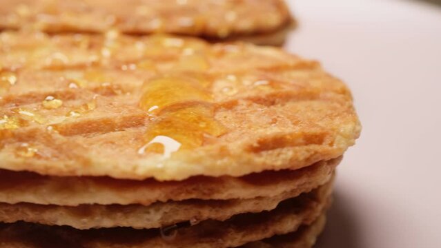 Close-up Belgium Crispy Butter Waffles pouring honey on 360 degree rotating plate