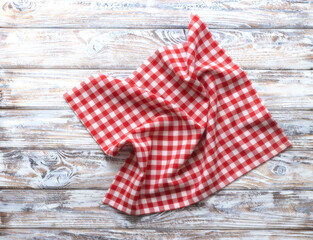 Red checkered picnic cloth top view on rustic wooden background empty copy space.