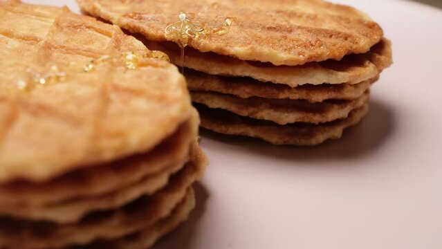 Close-up Belgium Crispy Butter Waffles pouring honey on 360 degree rotating plate