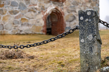 A fence made of iron chain. Granite fence post