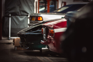 Row of cars in a garage including some classic motors.