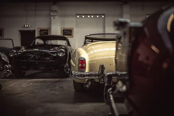 Poster Classic cars being restored in a vintage vehicle garage workshop © Pavel