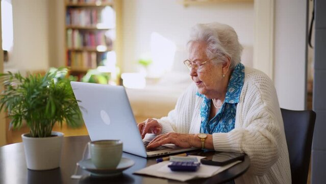 Senior woman reading notification about increased healthcare costs, bad medical test results, high utility bill. Elderly woman working on laptop, shopping online, risk of frauds and hoax for elderly