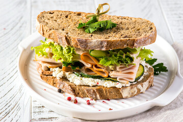 sandwich on bread with ham, cucumber and cream cheese