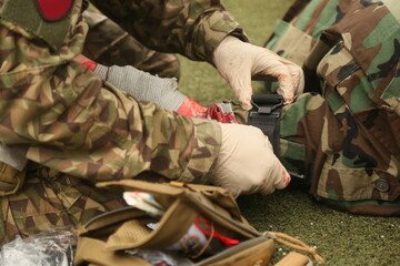 Medical exercise. Medical instructorputs on a tourniquet during an exercise