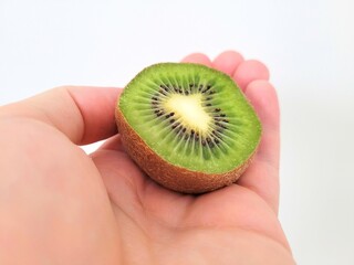 Sliced little kiwi on hand for vitamins portion.