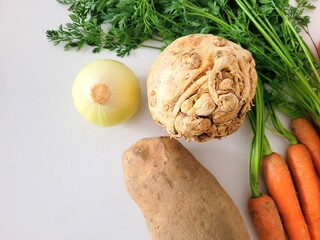 Vegetarian ingredients for a tasty soup – celery root, onion, potato and carrots.