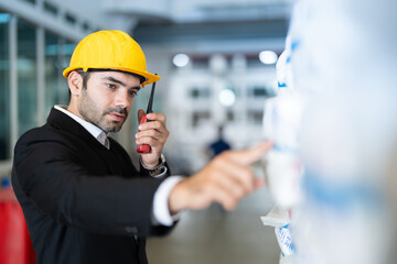 Closeup of European male executive, engineer pointing finger at plastic product holding radio to...