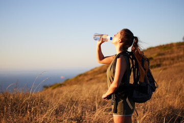 Woman, drink water and hiking outdoor for fitness or travel, thirst and hydration with exploring nature. Backpacking, adventure and trekking in New Zealand with h2o drink for nutrition and health - obrazy, fototapety, plakaty
