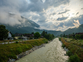 fast wild river with mountains in background in summer