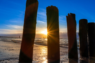 Beautiful golden hour beach sunset with glowing sun and colorful sky shows vibrant colors as north...