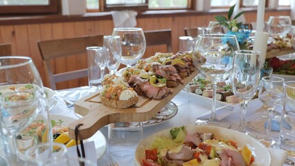 Catering at the banquet table with appetizers-canapes in the restaurant. Buffet and snacks at a business event. Beautifully decorated banquet table with appetizers from canapes.