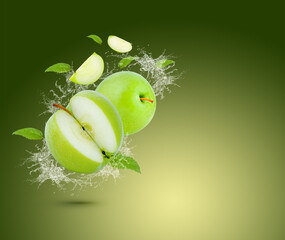 Water splash on fresh green apple with leaves isolated on green background