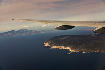 Obraz premium Beautiful view of the airplane wing and the island in the sea.
