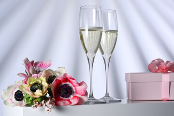 Two glasses with champagne, gift and flowers - 790176815