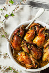 Baked quail stuffed with mushrooms, eggs and bread in a ceramic form on a wooden table. - 790177002