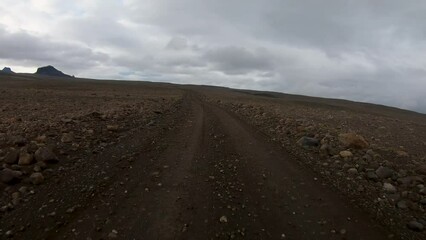 Driving Plate Front View POV Gravel Road Iceland F-Road Offroad Dirt on Cloudy Rainy Day.