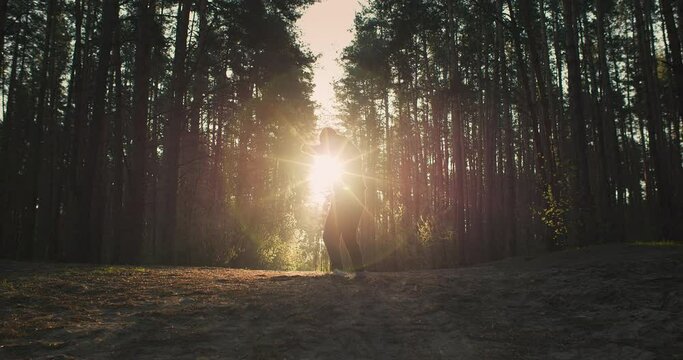 Wide shot of young man athlete training in the forest. Shadow boxing and running on sunrise in nature