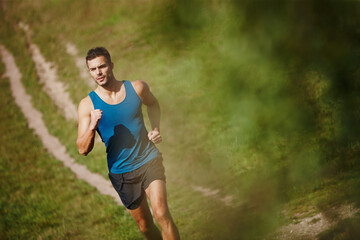 Running, athlete and man, trail and outdoor with energy for practice, exercise and health in...