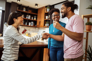 African American couple getting keys from their real estate agent, for their new home. Shaking hands. - 790198020