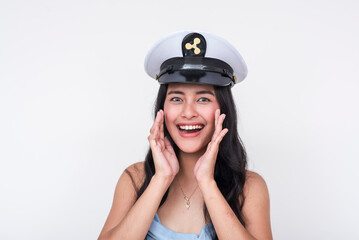 Joyful Asian woman in a captain's hat making an announcement, isolated on white