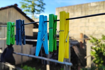 Isolated colorful clothespins hanging in a clothes line of a small farm.