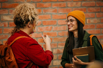 Shot of two female students talking about studying outside on campus