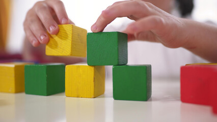 child playing cubes close-up. education a children development of fine motor skills concept. child close-up hands plays with blocks develops fine motor skills. kid plays lifestyle with cubes