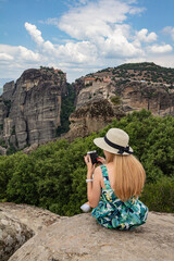 Girl sitting on a rock and taking pictures