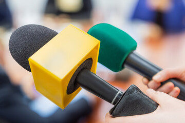 Interview with the press. Press conference, blurred background. journalist at news conference or media event, holding microphone.