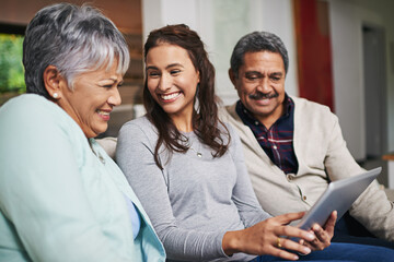 Obraz premium Senior parents, woman and tablet in living room for connection or bonding with tech. Family, home and mature people with young, female person and happy for togetherness on couch in community