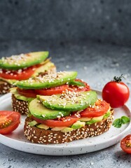 avocado, tomato and sesame seeds sandwiches; tasty breakfast; close up and copy space