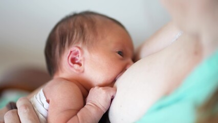 mother breastfeeds baby. newborn sucking a mother breast through a rubber nozzle. motherhood child...