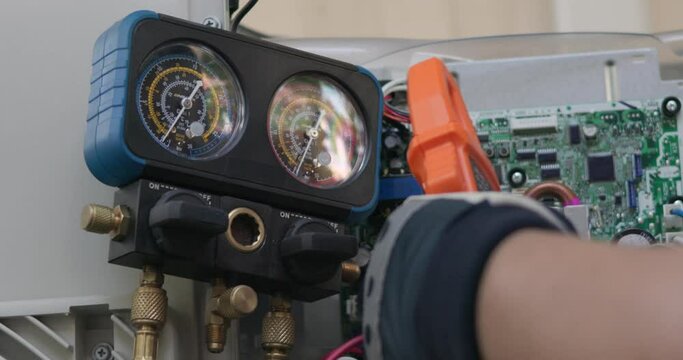 Air conditioner technician hand check condenser circuit by amp clamp meter,Air conditioner maintenance service, Home service concept