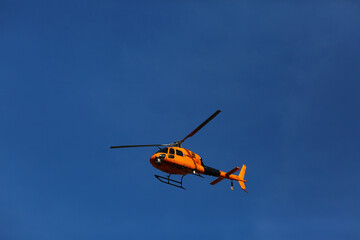 Fototapeta na wymiar yelow helicopter flying in the sky