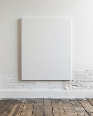 white walls and a blank white rectangular canvas in a studio with rough wooden floors