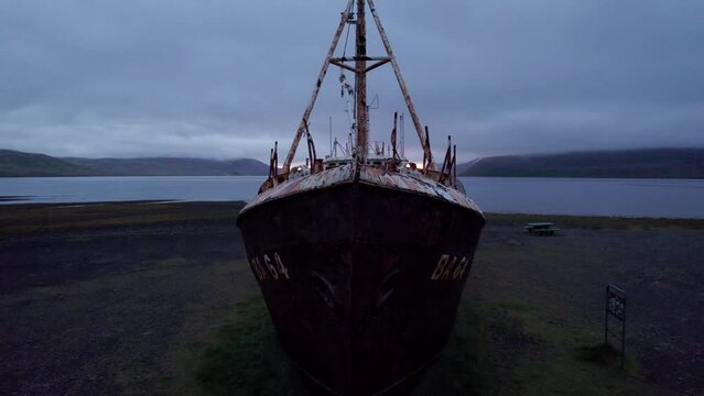 Iceland West Fjords Gardar Ship Wreck. Drone Flies From Low Up Over Antique Rusted Ship Sunset Fjord.