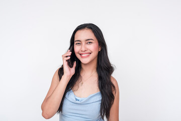 Smiling young woman in a baby blue dress talking on a cellphone