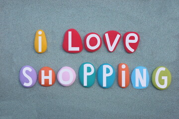 I love shopping, creative slogan composed with hand painted multi colored stone letters over green...
