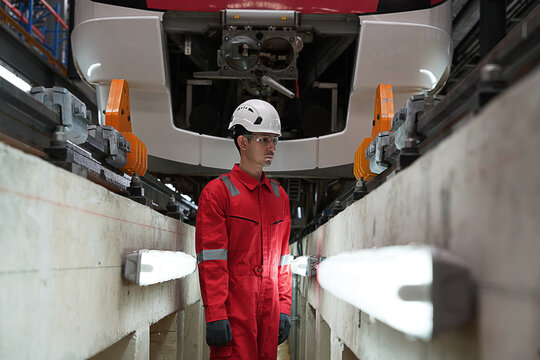 Electric Train Maintenance Training Center, male engineer employees wearing uniforms conduct safety inspections and control the work of electric train inspection technicians under the train tracks